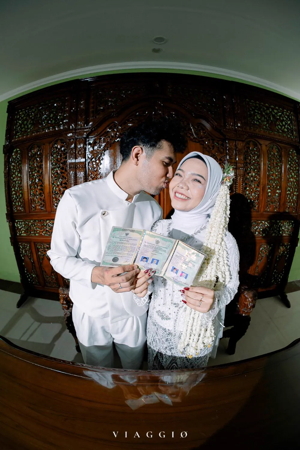 Pasangan menunjukkan buku nikah
